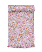 The Kissy Kissy Ruffle Blanket, featuring a charming floral pattern and pink ruffled edges, is shown partially rolled out on a white background—perfect for wrapping a little girl in cozy comfort.