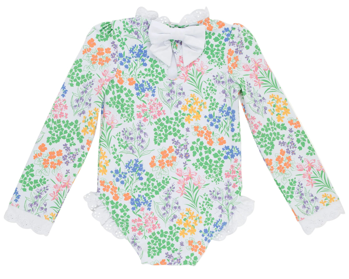 The Baby Girls’ and Girls’ Sarasota Surf Suit by The Beaufort Bonnet Company features long sleeves and a charming floral print in green, orange, purple, and pink. Detailed with a white bow at the collar and delicate lace trim on the sleeves and leg openings, this sweet style adds classic charm to your little one’s wardrobe.