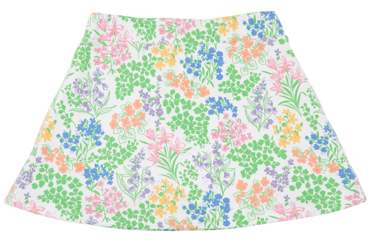 The Girls’ Searcy Skort by The Beaufort Bonnet Company features an A-line silhouette with a white base adorned with a vibrant floral pattern showcasing green leaves and pink, blue, orange, and purple flowers, all crafted from soft and durable Pima Cotton for lasting comfort.