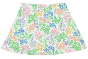The Girls’ Searcy Skort by The Beaufort Bonnet Company features an A-line silhouette with a white base adorned with a vibrant floral pattern showcasing green leaves and pink, blue, orange, and purple flowers, all crafted from soft and durable Pima Cotton for lasting comfort.