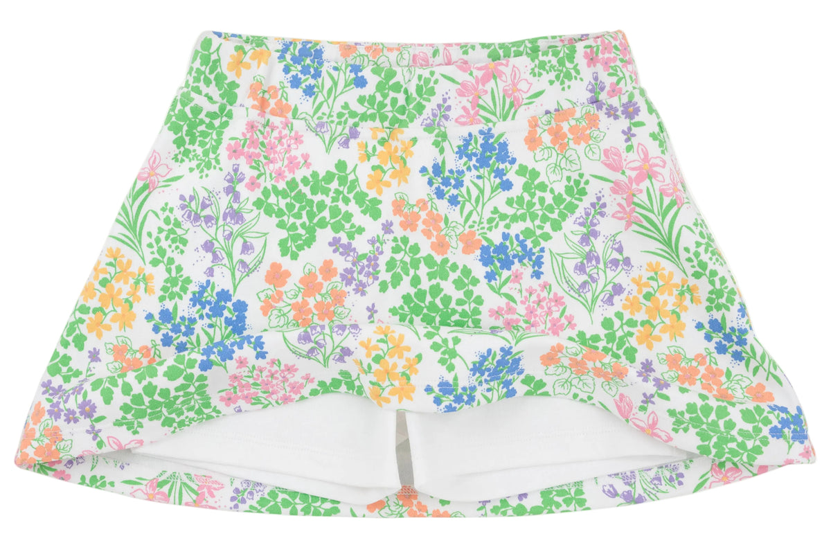 The Girls’ Searcy Skort by The Beaufort Bonnet Company is a white skort made from soft Pima Cotton, showcasing a vibrant floral pattern in shades of green, orange, pink, and blue. It features an elastic waistband and built-in white shorts for comfort and style.
