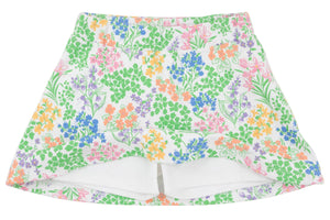 The Girls’ Searcy Skort by The Beaufort Bonnet Company is a white skort made from soft Pima Cotton, showcasing a vibrant floral pattern in shades of green, orange, pink, and blue. It features an elastic waistband and built-in white shorts for comfort and style.