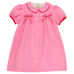 This charming dress—featuring short sleeves, a button-front design, Peter Pan collar, red trim, and two small red bows on the chest—resembles The Beaufort Bonnet Company’s Baby Girls’ and Girls’ Tabitha’s Teacher’s Pet Dress in their signature Hamptons Hot Pink.