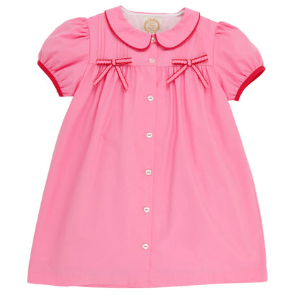 This charming dress—featuring short sleeves, a button-front design, Peter Pan collar, red trim, and two small red bows on the chest—resembles The Beaufort Bonnet Company’s Baby Girls’ and Girls’ Tabitha’s Teacher’s Pet Dress in their signature Hamptons Hot Pink.
