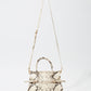 The Simkhai River Small Snake Top Handle Bag features a beige and brown snakeskin pattern, top handles, and a long adjustable shoulder strap, shown against a plain white background.