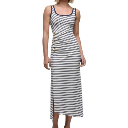 A woman wears the Simkhai Becker Cotton Jersey Midi Dress—sleeveless, white with navy stripes, side buttons, and a side slit—paired with white strappy sandals.