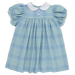 The Beaufort Bonnet Company’s Baby Girls’ and Girls’ Mary Dal Dress features the charming Audubon Park Plaid in light blue, with puffed short sleeves, a white scalloped collar, and two decorative flower buttons on the chest.