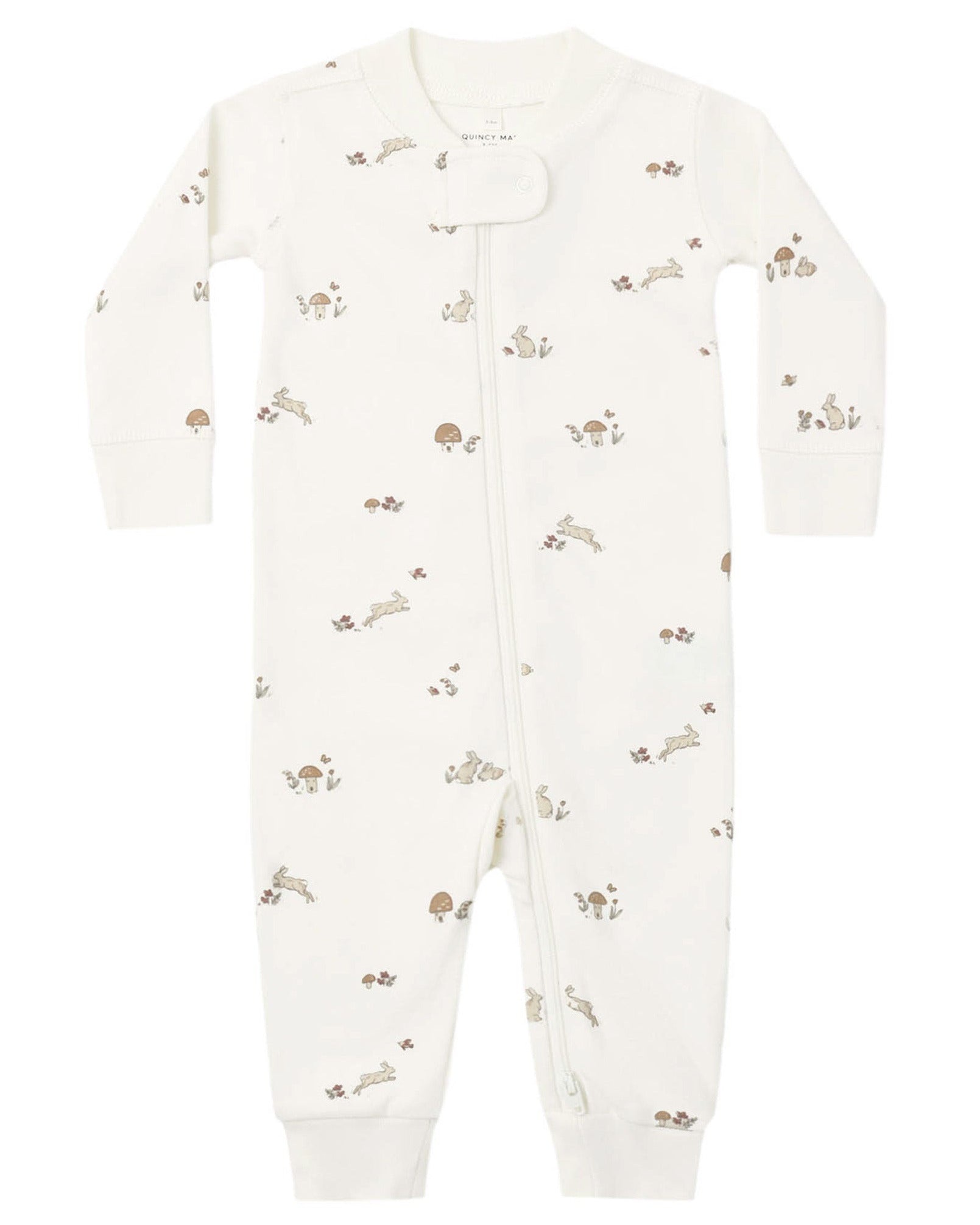 The Quincy Mae Baby Zip Long Sleeve Sleeper is a white onesie made from soft organic brushed jersey, featuring a diagonal zipper and a subtle pattern of small woodland animals and mushrooms in muted tones.