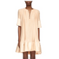 A person wearing Lanvin's Short Sleeve Cascade Dress, a loose knee-length design in light beige Korean satin with short sleeves and a V-neck lace-up detail.