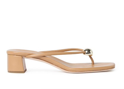 The Odessa Heeled Mule by Loeffler Randall is a tan dune nappa leather sandal with a mid heel, square toe, and an eye-catching gold ball detail on the upper strap.
