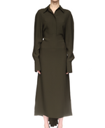 A person wears the Victoria Beckham Long Sleeve Polo Collar Midi in olive green with raglan sleeves, button-up front, and a feminine skirt, standing against a white background.