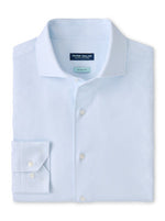 The Peter Millar Excursionist Flex Print Sport Shirt, made from Italian fabric in light blue, features a spread collar, front buttons, and visible cuffs, displayed neatly folded on a white background.