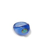 The Monument Ring by Lizzie Fortunato features a blue translucent hand-blown glass band with a small circular green stone set in a gold bezel on one side, shown against a white background.