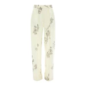The Victoria Beckham Floral Wide Leg Trouser features a cream color, high-rise fit, straight-leg cut, and a black/off white floral and landscape print.