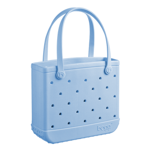 The Baby Bogg Bag by Bogg Bags is a light blue tote with two handles, ventilation holes, and "bogg" embossed near the bottom. This washable bag is practical and stylish for everyday use.