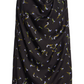 The Sleary Top by Altuzarra is an elegant sleeveless blouse crafted from black fabric draped vertically and adorned with a scattered floral pattern in pale blue, green, and yellow hues, featuring a graceful cowl neckline.
