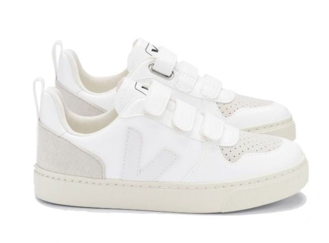 A pair of Veja Kids' V-10 Velcro CWL Sneakers, crafted from organic cotton with light grey accents and featuring perforated details, Velcro straps, and a white sole made from Amazonian rubber.