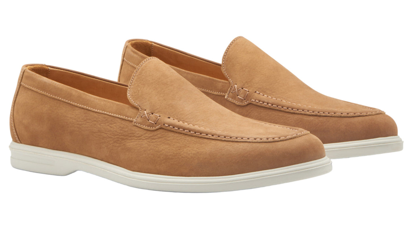 The Peter Millar Excursionist Nubuck Venetian Loafer, shown in light brown with white rubber soles on a white background, offers versatile and lightweight comfort for everyday wear.