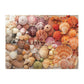 A completed 1000-piece Vibrant Seashells Puzzle by Mudpuppy, featuring assorted seashells and starfish in a variety of colors and sizes arranged closely together.