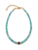 Introducing the Hidden Stone Necklace by Lizzie Fortunato: a graduated bead necklace crafted with turquoise and amazonite beads, highlighted by gold spacer accents, a central maroon bead, and completed with a gold adjustable chain clasp.