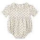 The Rylee & Cru Baby Girls’ Liv Romper features a vintage-inspired cream color, short puffed sleeves, a delicate ruffled scalloped collar, and an all-over small floral print pattern.