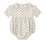 The Rylee & Cru Baby Girls’ Liv Romper features a vintage-inspired cream color, short puffed sleeves, a delicate ruffled scalloped collar, and an all-over small floral print pattern.