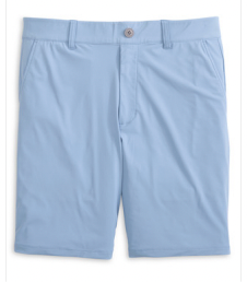 The Fusionn Short by Johnnie-O is a light blue, knee-length performance short in a classic chino style, crafted from comfortable stretch-knit fabric. It features a button closure, belt loops, and two front pockets, and is displayed against a white background.