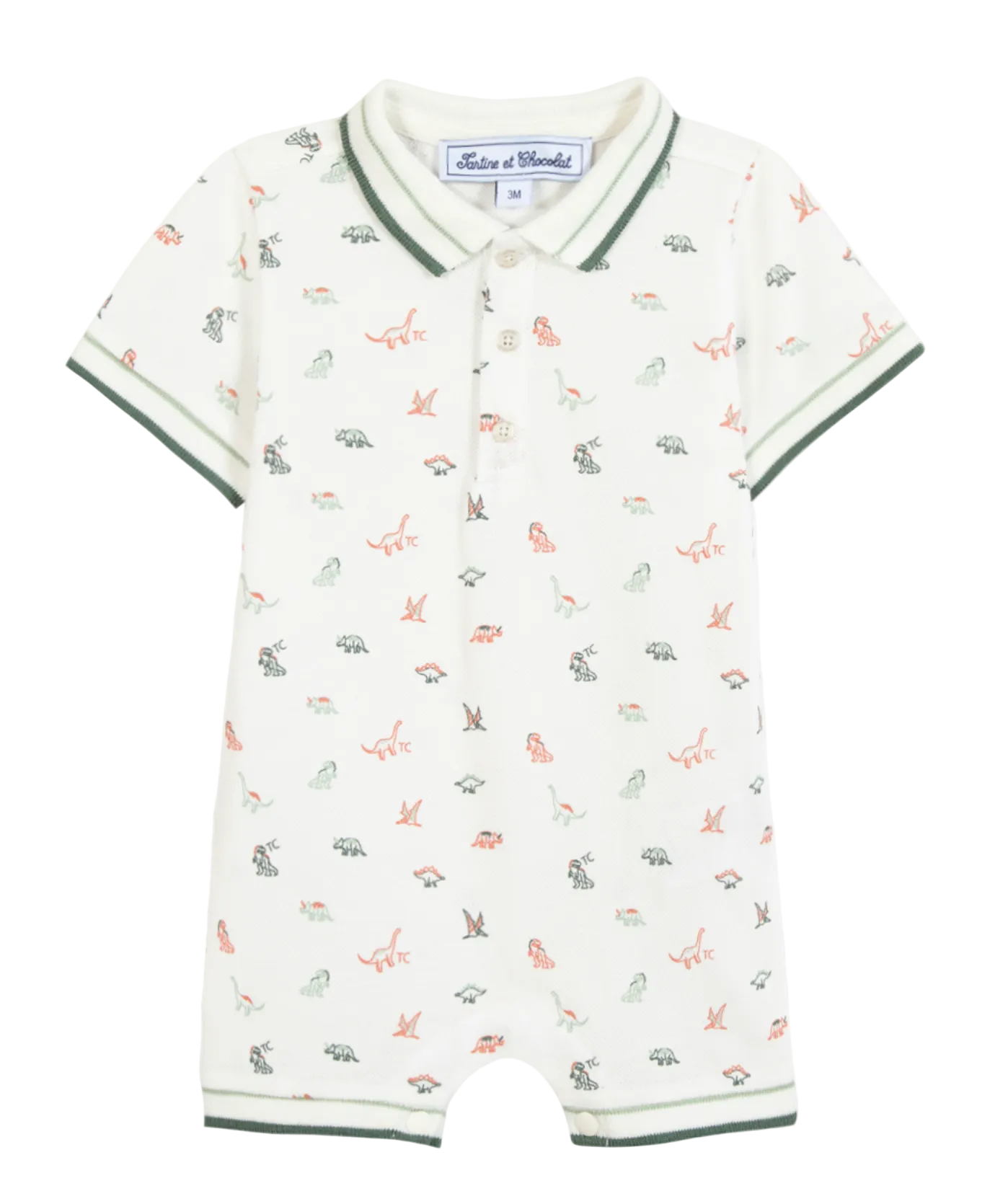 The Tartine et Chocolat Baby Boys’ Short Jumpsuit is a short-sleeve cotton romper with a collar and button placket, featuring a playful dinosaur illustration and green trim on the sleeves, collar, and leg openings.