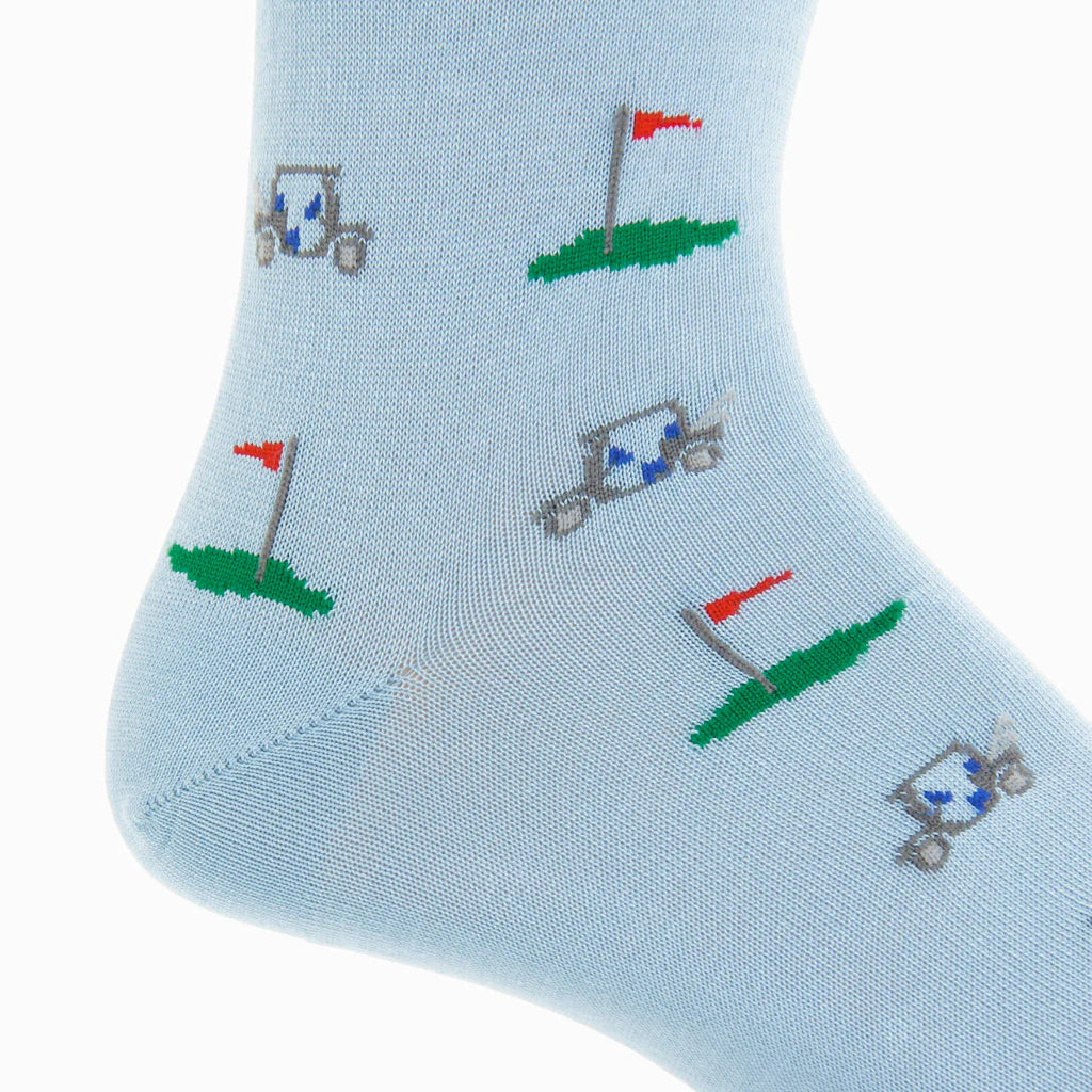 The Dapper Classics Golf Cart Cotton Mid-Calf Sock features light blue fabric with small golf carts and red flag golf holes on green patches—ideal for adding a stylish touch to your outfit.