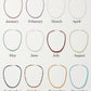 Twelve Jia Jia Birthstone Necklaces, each featuring vibrant semi-precious gemstones representing the months from January to December, are displayed in a grid on a white background.