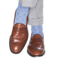 A pair of brown leather loafers accompanied by Dapper Classics Dot Mid Calf Socks in blue with pink polka dots, crafted from luxurious mercerized cotton, paired with gray trousers.