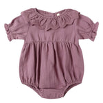 The Quincy Mae Baby Girls' Collared Romper features mauve fabric, puff sleeves, a ruffled collar, gathered waist, and handy snap closures at the bottom.
