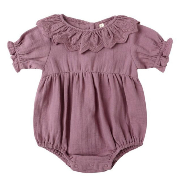 The Quincy Mae Baby Girls' Collared Romper features mauve fabric, puff sleeves, a ruffled collar, gathered waist, and handy snap closures at the bottom.
