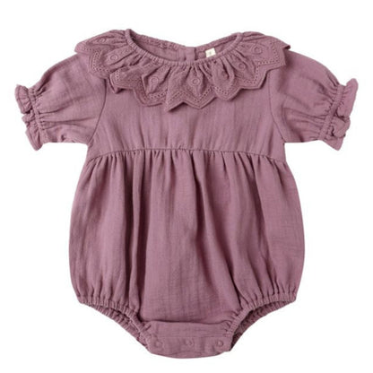 The Quincy Mae Baby Girls' Collared Romper features mauve fabric, puff sleeves, a ruffled collar, gathered waist, and handy snap closures at the bottom.
