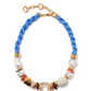 The Lizzie Fortunato Glass Beach Necklace features a blue braided cord, gold chain clasp, and an array of gold, freshwater pearls, white, and coral-colored beads.