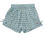 The Girls’ Jules Short by Pink Chicken showcases a Blue Prairie Blockprint adorned with a charming green and white leaf pattern, featuring an elastic waist for extra comfort, adorable side bows, and a small pink butterfly logo near the bottom hem.