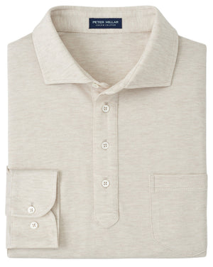 The Peter Millar Amble Long-Sleeve Cotton Cashmere Polo is a beige shirt with a front pocket, four buttons, and a brand label inside the collar.