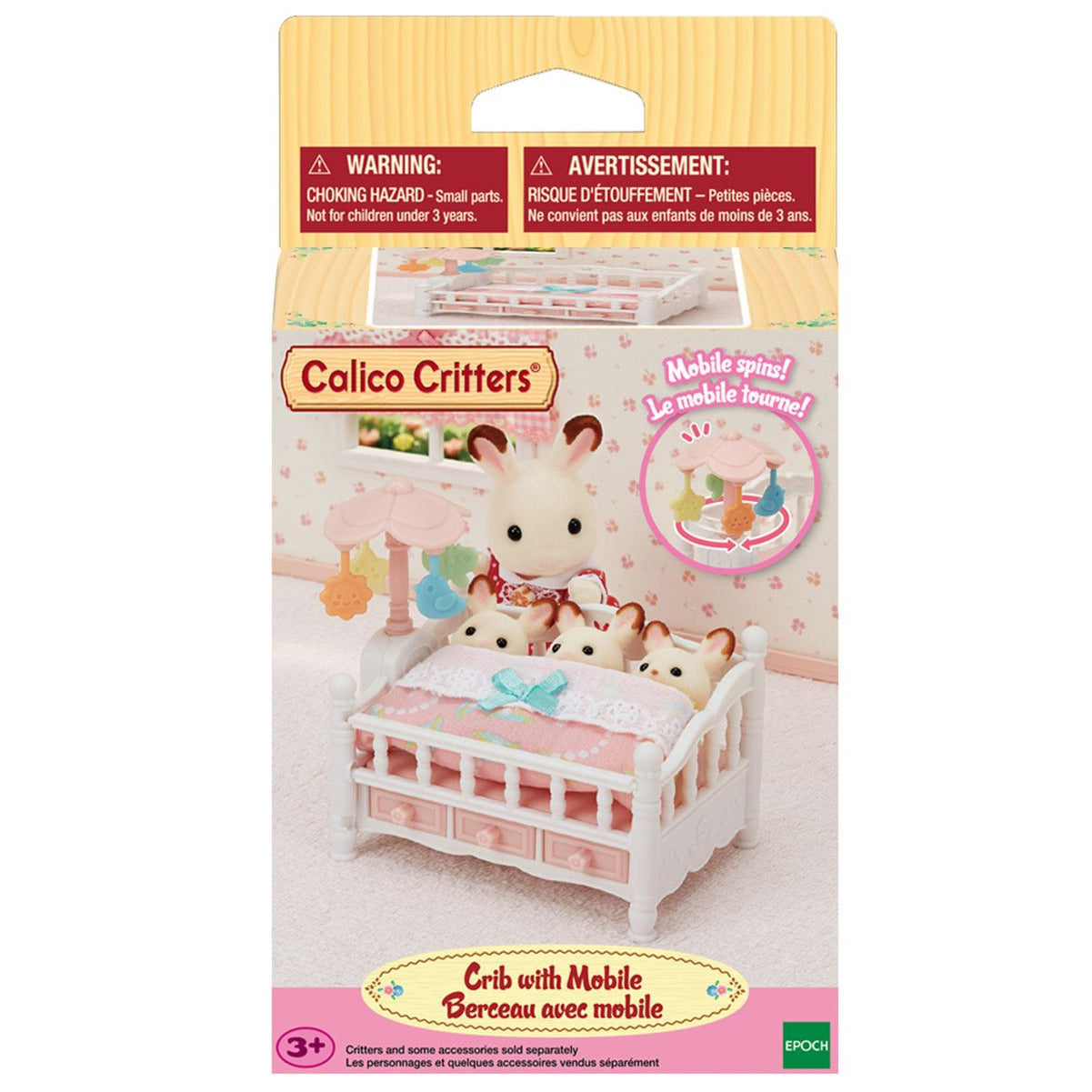 The Calico Critters Crib with Mobile comes in packaging and features a crib with an attached mobile, along with three small animal figures. This adorable baby nursery set from Calico Critters includes dollhouse furniture perfect for imaginative play. The packaging displays warnings and is recommended for ages 3 and up.