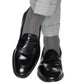 Person wearing light gray dress pants, Dapper Classics Steel Gray Solid Ribbed Cotton Sock Linked Toe Mid-Calf, and black leather loafers, standing with one leg crossed over the other against a white background.