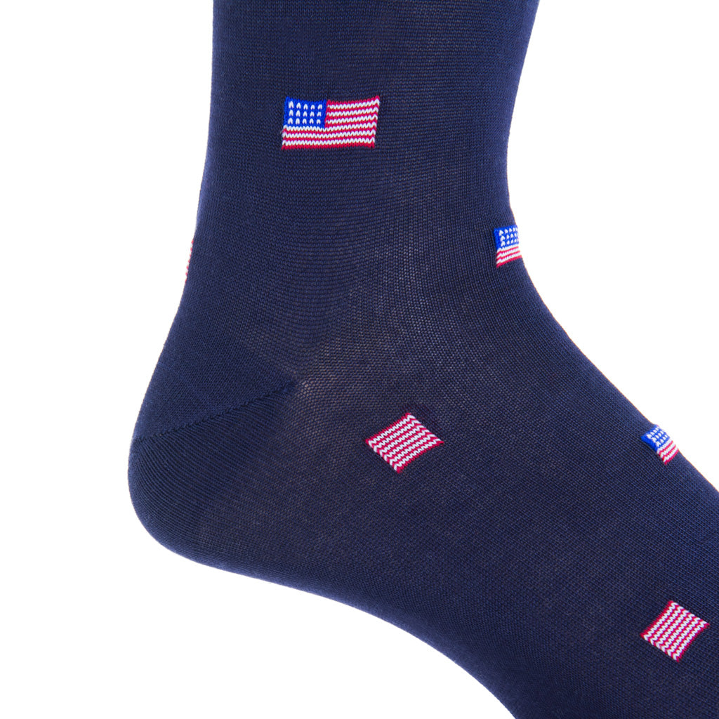 Close-up of a Dapper Classics navy sock in mercerized cotton, showcasing a pattern of small American flags. Crafted with breathable material and designed for a comfortable mid-calf fit, perfect for all-day wear.