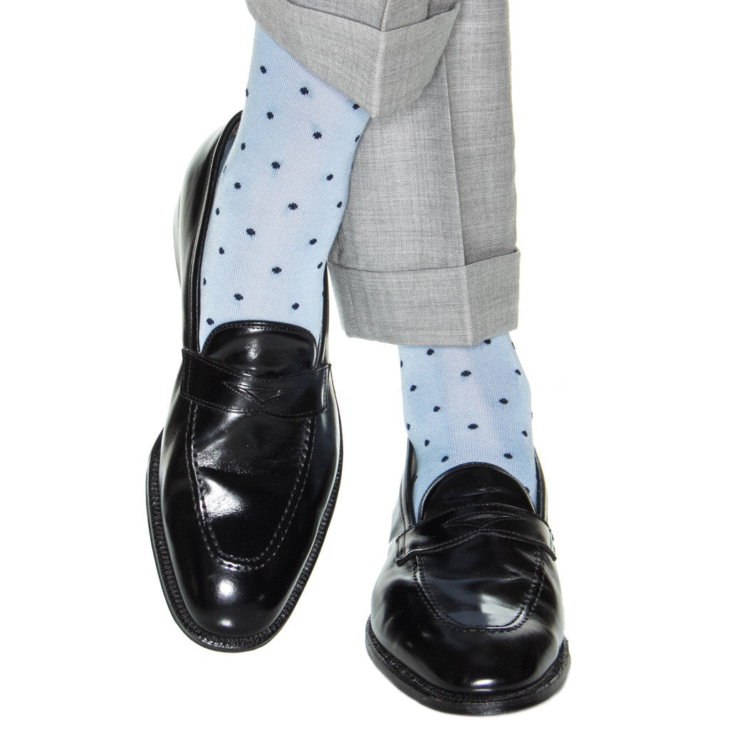 The black dress shoes are elegantly complemented by Dapper Classics Dot Mid Calf Socks in light blue polka dot, crafted from luxurious Mercerized Cotton, and perfectly paired with gray cuffed pants. The mid-calf fit of these Dapper Classics socks adds a stylish touch to this chic ensemble.