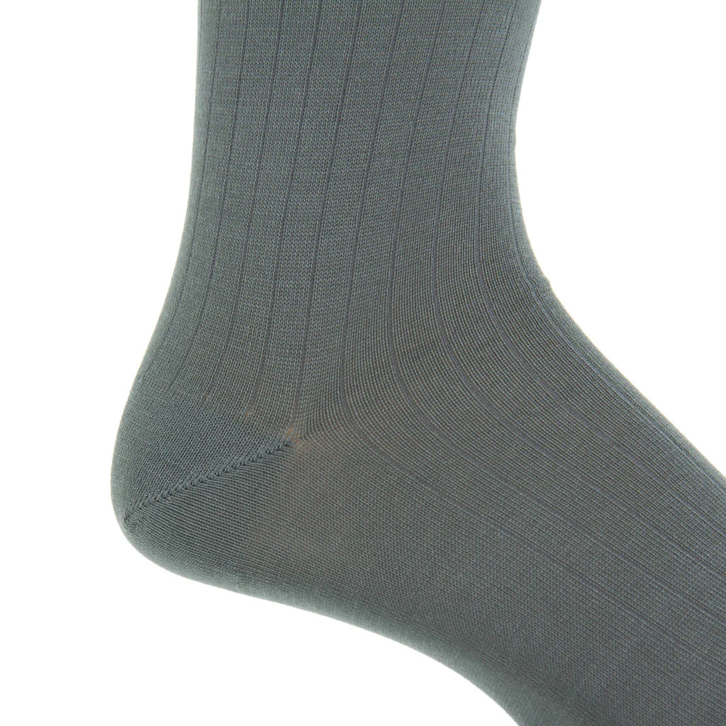 Close-up of the Dapper Classics Steel Gray Solid Ribbed Cotton Sock with a linked toe, shown worn on a foot at mid-calf height, highlighting the ankle and heel against a white background.