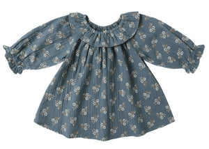 The Quincy Mae Baby Girls' and Girls' Long Sleeve Isla Dress features a blue cotton fabric with white floral print and a ruffled collar, shown on a white background.