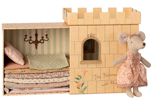 A Maileg Princess and the Pea - Big Sister Mouse, dressed in a lovely outfit, stands beside a cardboard castle with a charming stacked bedding set—perfect for fairytale play inspired by "The Princess and the Pea.