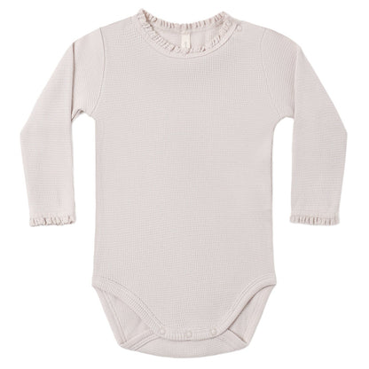 The Quincy Mae Baby Girls’ Waffle Long Sleeve Bodysuit features a light pink hue, ribbed texture, crochet lace ruffle at the neckline and cuffs, and convenient snap closures at the bottom and shoulder.