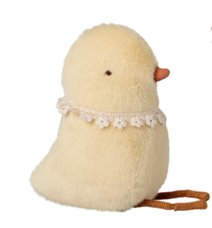 A Maileg Chicken Plush - Small features soft yellow fabric, a tiny orange beak, black eyes, a delicate white floral lace collar, and a brown strap. Set against a white background, it’s perfect for adding charm to any Easter basket.