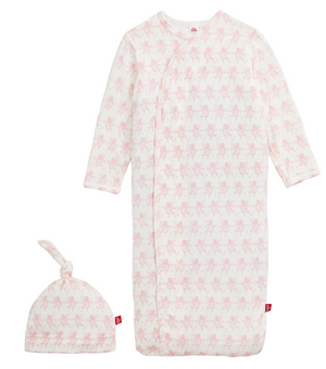 The Magnetic Me Baby Trunkettes Modal Gown + Hat set features a long-sleeve pink and white patterned newborn gown with a matching knotted hat, both adorned with a subtle animal print. Designed for comfort, this cozy modal set includes a convenient magnetic closure for easy dressing and changing.