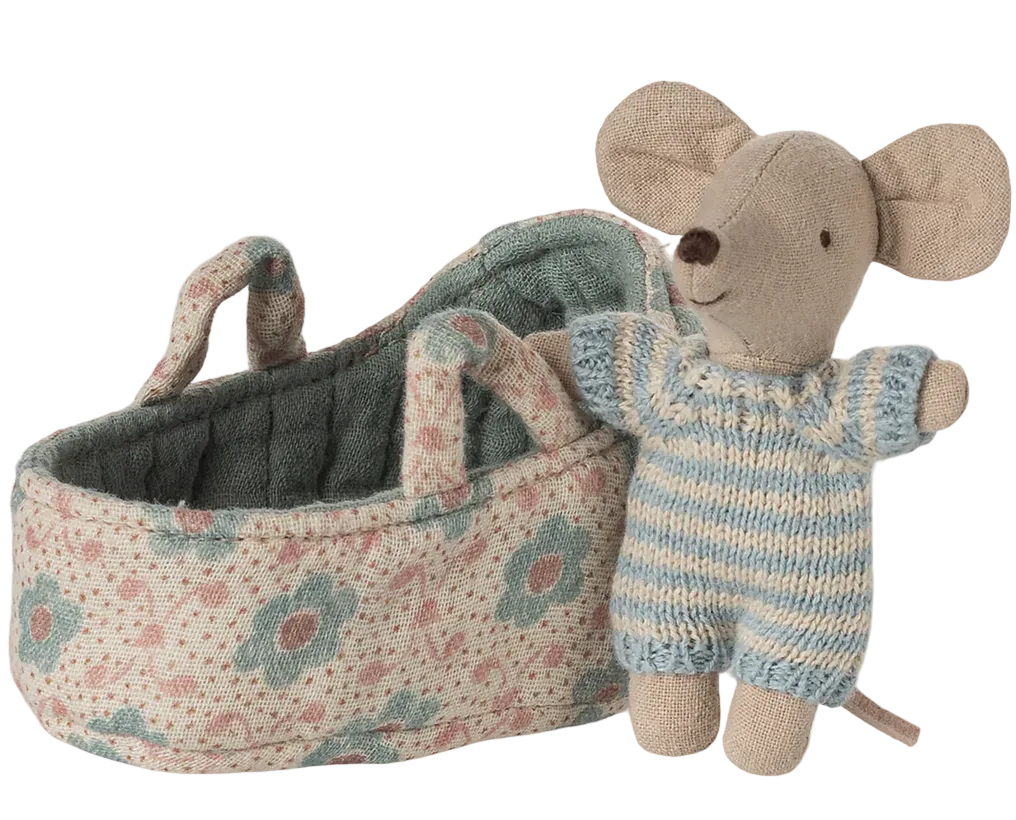 The Maileg Baby Mouse in Carry Cot - Blue features a tiny baby mouse dressed in a blue and white striped outfit, nestled inside a soft, floral-patterned fabric basket with handles—perfect as an adorable travel cradle or carry cot for imaginative playtime adventures.