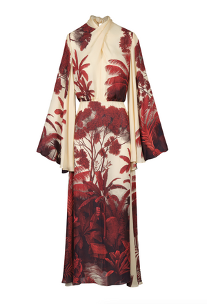 The Maiden Voyage Ankle Dress by Johanna Ortiz is a cream and burgundy silk georgette gown with wide sleeves, showcasing a nature-inspired print of trees and plants reminiscent of the Colombian landscape.