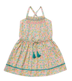 The Early Sunday Girls’ Alisson Dress is a sleeveless, floral mint dress for girls featuring a smocked bodice, teal tassel ties, criss-cross straps, and rickrack trim near the hem. This pastel summer dress is perfect for sunny days.